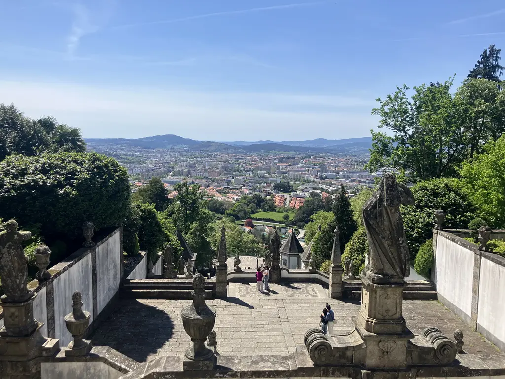 Vista panorámica de la ciudad de Braga desde uno de los descansos del santuario, rodeado de estatuas y jardines.